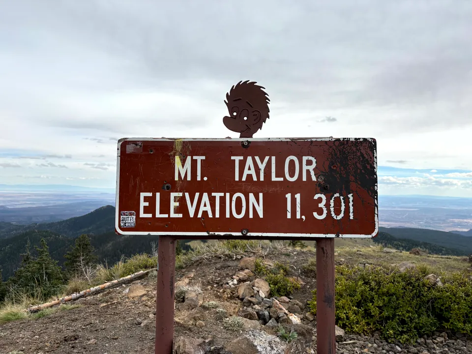 A sign on top of Mount Taylor